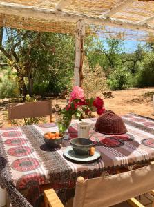 a table with two bowls of fruit and flowers on it at Charming Country House in Poço do Álamo