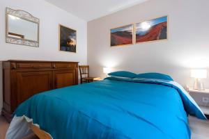a bedroom with a blue bed and a dresser at Gite Nature L'orée Des Etoiles in Soultzeren