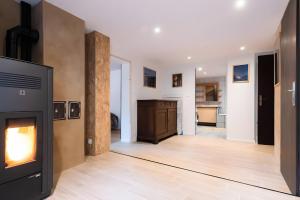 a living room with a fireplace and a kitchen at Gite Nature L'orée Des Etoiles in Soultzeren