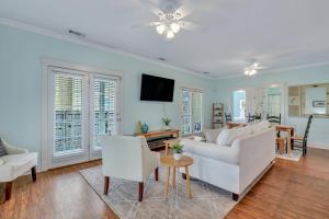 ein Wohnzimmer mit einem weißen Sofa und Stühlen in der Unterkunft Thunderbolt Bungalow by Lucky Savannah in Savannah