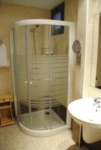 a glass shower in a bathroom with a sink at Hotel Alegría in Baños de Montemayor