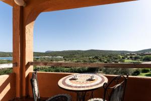 a table and chairs on a balcony with a view at Relaxing BaiaDeBahas 1BedApt Bilo4 sleeps4 SeaView in Marinella