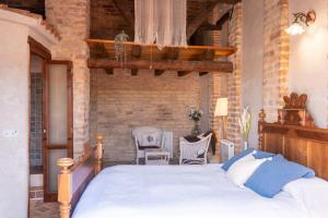 a bedroom with a bed and a brick wall at La Festa Dels Sentits, Casa Rural in Sant Martí de Maldá +36 photos