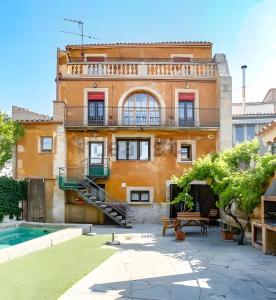 an old building with a pool in front of it at La Festa Dels Sentits, Casa Rural in Sant Martí de Maldá