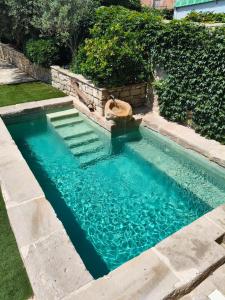 a swimming pool with blue water in a yard at La Festa Dels Sentits, Casa Rural in Sant Martí de Maldá