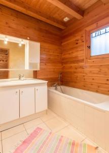 オトリュスにあるChalet Lo Capstoaの木製の壁のバスルーム(バスタブ、シンク付)
