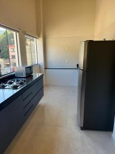 a kitchen with a refrigerator and a counter top at Loft Toscana in Santa Teresa +4 photos