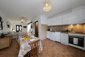 una cucina e un soggiorno con un tavolo e una sala da pranzo di Acolhedora Casa Tradicional a Asseca