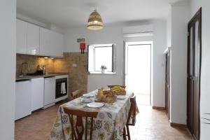una cucina con tavolo e tovaglia di Acolhedora Casa Tradicional a Asseca Altre 2 foto