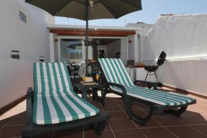 two chairs and an umbrella on a patio at Casa Tradicional Algarvia in Tavira