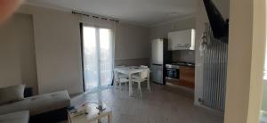 a living room with a table and a kitchen at Il Nido di Chiara in Formia