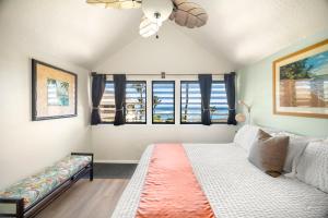 a bedroom with a bed and a couch and windows at Kaha Lani 212 - Oceanfront 2BR Condo with Pool, Tennis & BBQs in Wailua +44 photos