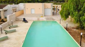 una vista sul soffitto di una piscina con sedie e di una casa di Porto Selvaggio Villa a Santa Caterina di Nardò