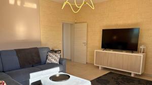 un soggiorno con un divano blu e una TV a schermo piatto di Porto Selvaggio Villa a Santa Caterina di Nardò