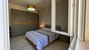 una camera da letto con un letto e una grande finestra di Porto Selvaggio Villa a Santa Caterina di Nardò Altre 17 foto