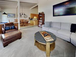 een woonkamer met een bank en een tafel bij Summer Fun - SLOPESIDE 4BR 3BA with 3 Spas, Pool and Sauna - Perfect for Family and Friend Getaways All Year Round 1849 Condos 693 condo in Mammoth Lakes