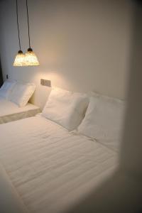 a bed with white sheets and pillows in a room at Yunxi Courtyard in Zhangzhou