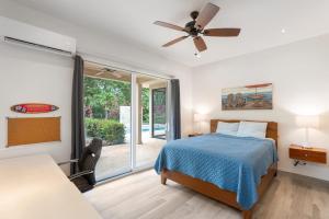 a bedroom with a bed and a ceiling fan at Beautiful Home in a Gated Neighborhood Walking Distance to the Beach with Garden Views and a Pool in Brasilito