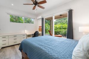 a bedroom with a blue bed and a window at Beautiful Home in a Gated Neighborhood Walking Distance to the Beach with Garden Views and a Pool in Brasilito +22 photos