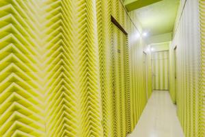 un couloir avec un mur jaune dans l'établissement SPOT ON The Space Resto & Rooms, à Gulzārbāgh