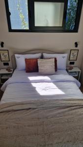 a bedroom with a large white bed with a window at LuxEcoCottage in Podgorica