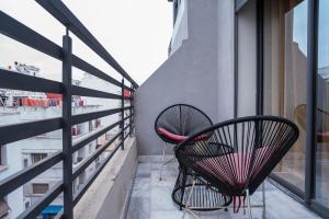 two chairs sitting on the balcony of a building at Awesome place with city view maarif casablanca in Maarif