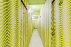 un long couloir avec des murs et des fenêtres jaunes dans l'établissement SPOT ON The Space Resto & Rooms, à Gulzārbāgh