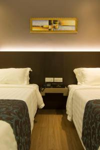 Postel nebo postele na pokoji v ubytování Hotel Anika Kluang