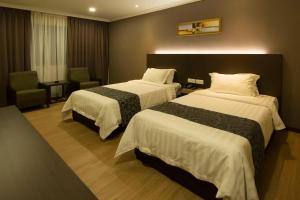 Postel nebo postele na pokoji v ubytování Hotel Anika Kluang + 33 fotografií