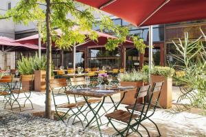 an outdoor patio with tables and chairs and a building at NH Vienna Airport Conference Center in Schwechat