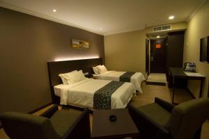 Postel nebo postele na pokoji v ubytování Hotel Anika Kluang