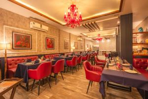 un ristorante con tavoli, sedie e un lampadario di The Rampour Rishikesh - A Brigadiers Cottage Collection a Rishikesh