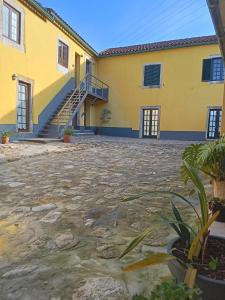 a yellow building with stairs in front of it at DF Alojamentos e suites in Coimbra