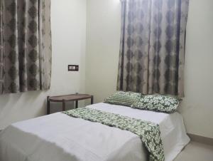 North ParavurにあるCherai beach homeのベッドルーム1室(白いシーツと緑の枕が備わるベッド1台付)