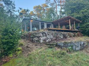 a house sitting on top of a stone wall at Pine Hill in Karlarp