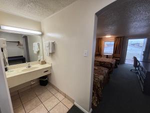 a bathroom with a sink and a bed in a room at Hotel O Haven Inn Huntsville AL US 72 in Huntsville +27 photos
