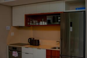 a kitchen with a stainless steel refrigerator and cabinets at Zimbali Hotel Unit 422 Suites in Ballito