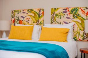 a bedroom with a bed with yellow and blue pillows at Zimbali Hotel Unit 422 Suites in Ballito +22 photos