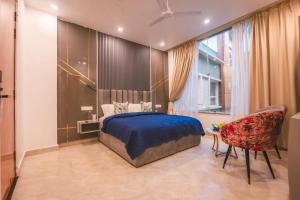 una camera da letto con un letto blu e una sedia di The Rampour Rishikesh - A Brigadiers Cottage Collection a Rishikesh Altre 24 foto