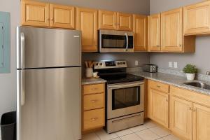 Una cocina con gabinetes de madera y un refrigerador de acero inoxidable. en Playhouse Square Downtown, Rock Hall, Clinic, CSU, en Cleveland