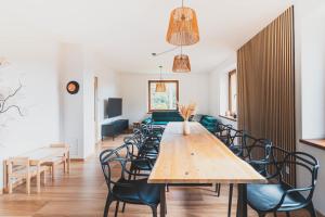 a dining room with a wooden table and chairs at DOMEK Písařov - apartmány in Písařov