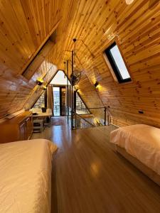 Zimmer mit 2 Betten an einer Holzdecke in der Unterkunft أكواخ المها oryx cottage in Adschlun