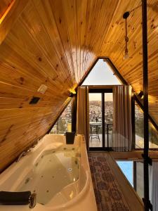eine Badewanne in einem Zimmer mit Holzdecke in der Unterkunft أكواخ المها oryx cottage in Adschlun