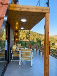 eine Terrasse mit einer Bank, einem Tisch und Stühlen in der Unterkunft أكواخ المها oryx cottage in Adschlun