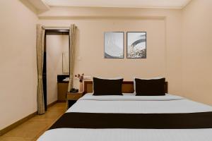 Un dormitorio con una cama grande con dos almohadas. en Townhouse The 36 Inn Madhuravada Bus Stop, en Rushikonda