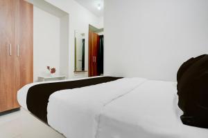 a bedroom with a white bed and a mirror at Hotel O Arrow Inn in Bengaluru +22 photos