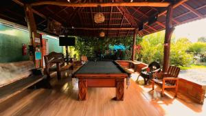 a ping pong table in a room with chairs at Hotel Borari in Alter do Chao