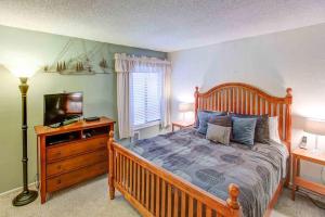 a bedroom with a wooden bed and a television at Fireside Pool Access Hot Tub & More in Mammoth Lakes