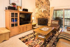 a living room with a television and a fireplace at Chamonix Year-Round Fun with Shared Pool in Mammoth Lakes