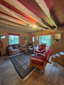 una cabina dotata di soggiorno con divani e tavoli. di La Maison de l'Etang a Manerbe